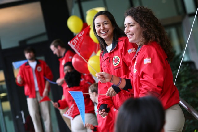 Group oif AmeriCorps members greeting with City Year flags