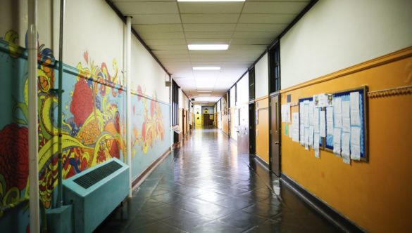 A school hallway with murals and bulletin boards.