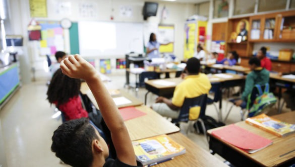 Student at a City Year School raises their hand