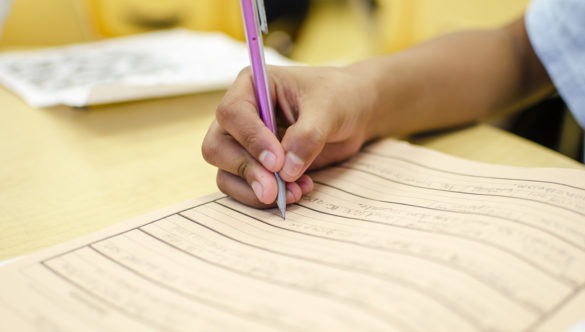 close up of student writing in a notebook