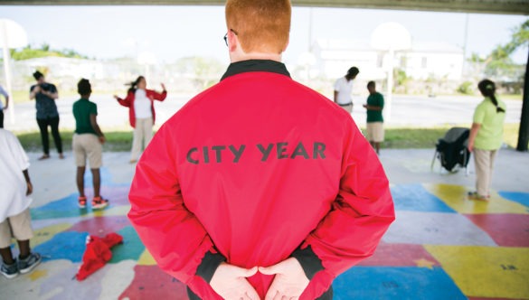 City Year AmeriCorps member with students on a playground