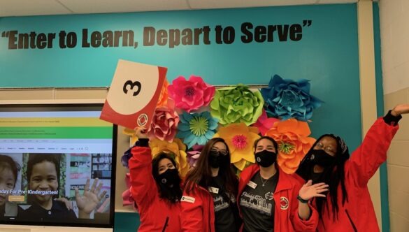 City Year AmeriCorps members red jacket in school